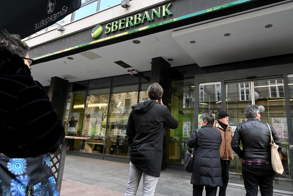 Citizens wait in front of the entrance of a branch of the Russian Sbertbank in the center of Zagreb on February 28, 2022. - Citizens rushed to the bank in an attempt to retrieve their money following last week's Russian attack on Ukraine. The ruble collapsed against the dollar and the euro on the Moscow Stock Exchange on February 28, 2022, as the West punished Moscow with harsh new sanctions over the Kremlin's invasion of Ukraine. President Vladimir Putin raged against the West as he convened a meeting with officials including central bank chief Elvira Nabiullina and the CEO of Russia's largest lender Sberbank, German Gref, to address what the Kremlin called a new 