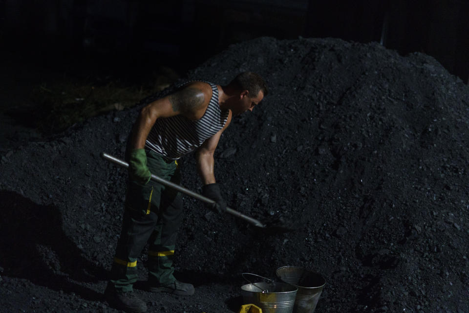 Kostya, one of three men working a 12-hour night shift, shovels coal to heat the boilers at a bakery in Kostiantynivka, Donetsk region, eastern Ukraine, Monday, Aug. 15, 2022. One advantage with the coal system is that the plant will not need additional heating in winter. There will be no central heating in the region this winter due to the lack of gas. (AP Photo/David Goldman)