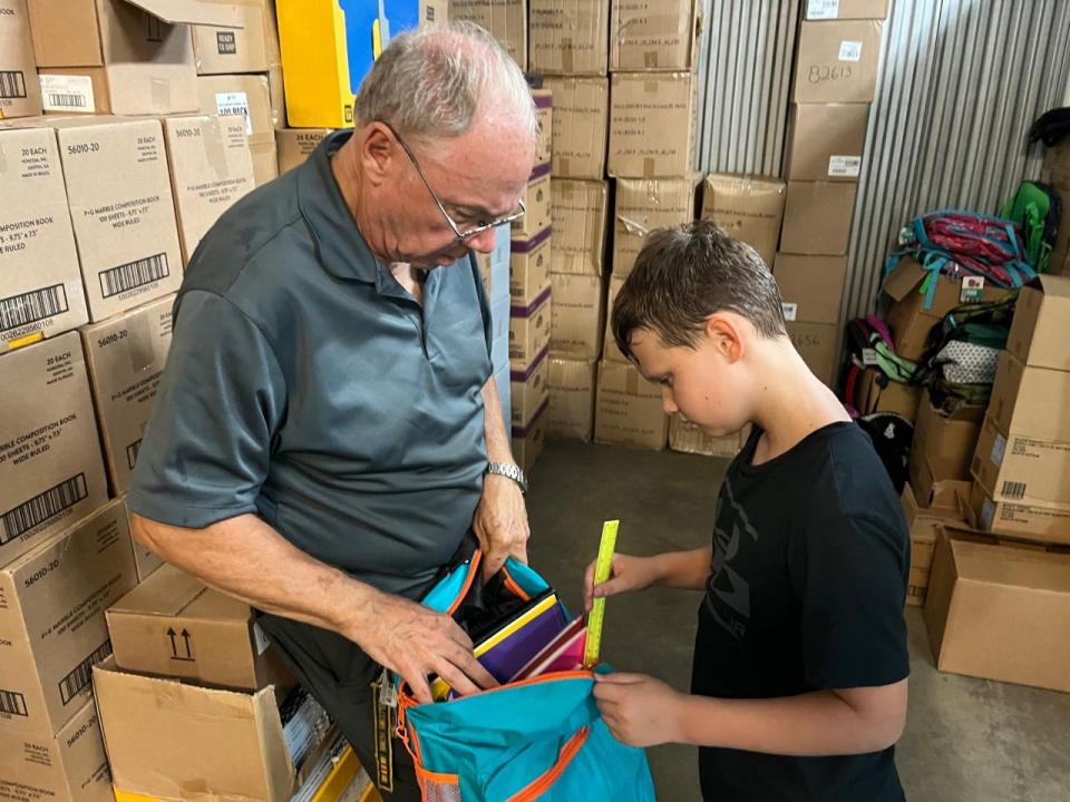 Retired U.S. Army Col. Craig Ham and his grandson Brady Collins, 11, wrap up a volunteer session for the Stuff the Bus program in southwest Ocala on June 25.