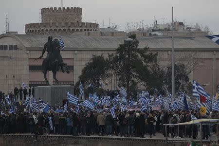 Protesters wave Greek national flags next to a statue of Alexander the Great during a rally against the use of the term "Macedonia" in any solution to a dispute between Athens and Skopje over the former Yugoslav republic's name, in the northern city of Thessaloniki, Greece, January 21, 2018. REUTERS/Alexandros Avramidis