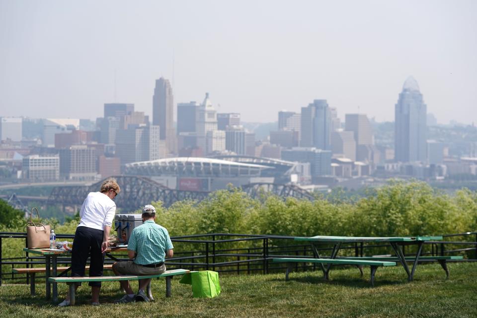 John and Kristen Carson sit for lunch on their way back home to Indianapolis from a road trip to South Carolina, on Tuesday. Smoke from wildfires in Canada has drifted southward to Cincinnati, causing the air to appear hazy.