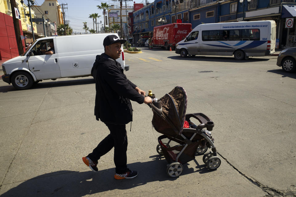 In this March 5, 2019, image, Juan Carlos Perla pushes his youngest son, Joshua, in a stroller along a street in Tijuana, Mexico. Perla’s experience suggests that a new policy forcing asylum seekers to wait in Mexico may be having its intended effect of discouraging asylum claims. Trump administration officials say they want to deter weak claims, freeing up judges to consider more deserving cases. (AP Photo/Gregory Bull)