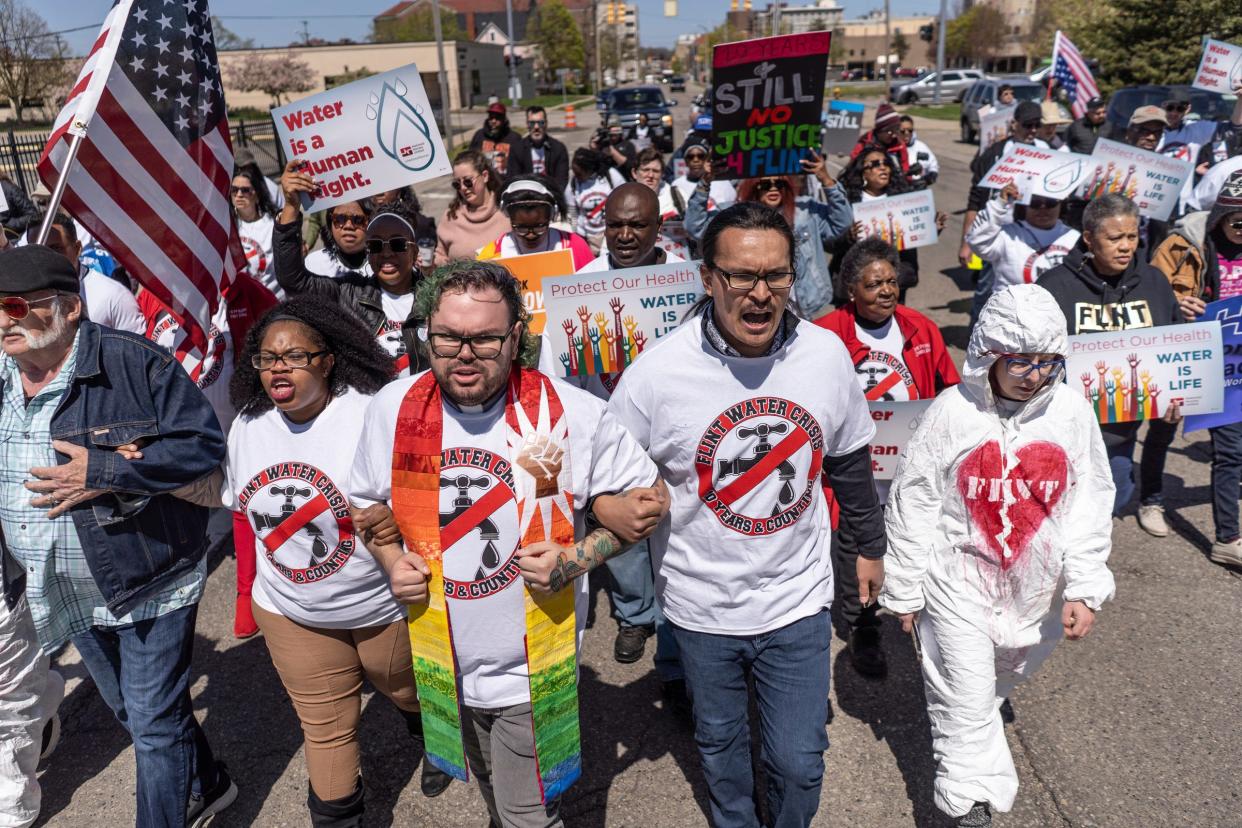 People march along Garland Street in downtown Flint during the 10th anniversary commemoration of the start of the Flint water crisis on Thursday, April 25, 2024.