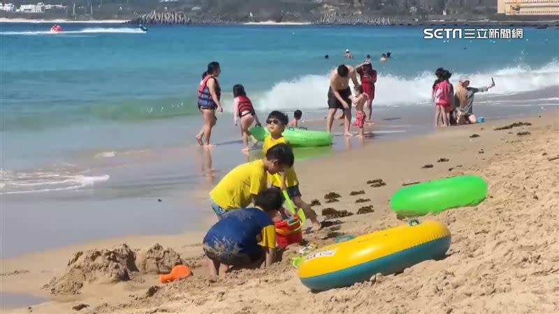 墾丁海邊戲水遊客多。