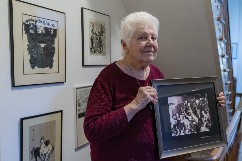 Peggy Simpson holds a photograph of law enforcement carrying Lee Harvey Oswald's gun through a hallway packed with reporters, Friday, Nov. 17, 2023, at her home in Washington. Simpson, a former Associated Press reporter, is among the last surviving witnesses to the events surrounding the assassination of Kennedy are among those sharing their stories as the nation marks the 60th anniversary. (AP Photo/Jacquelyn Martin)