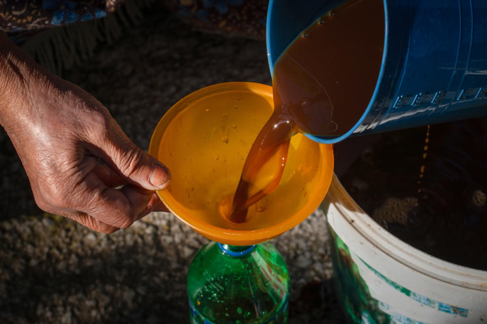 hands funneling a drink back into a bottle