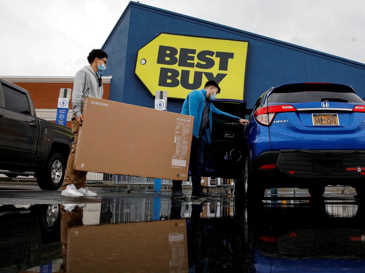 Customers load TV into back of SUV outside Best Buy store