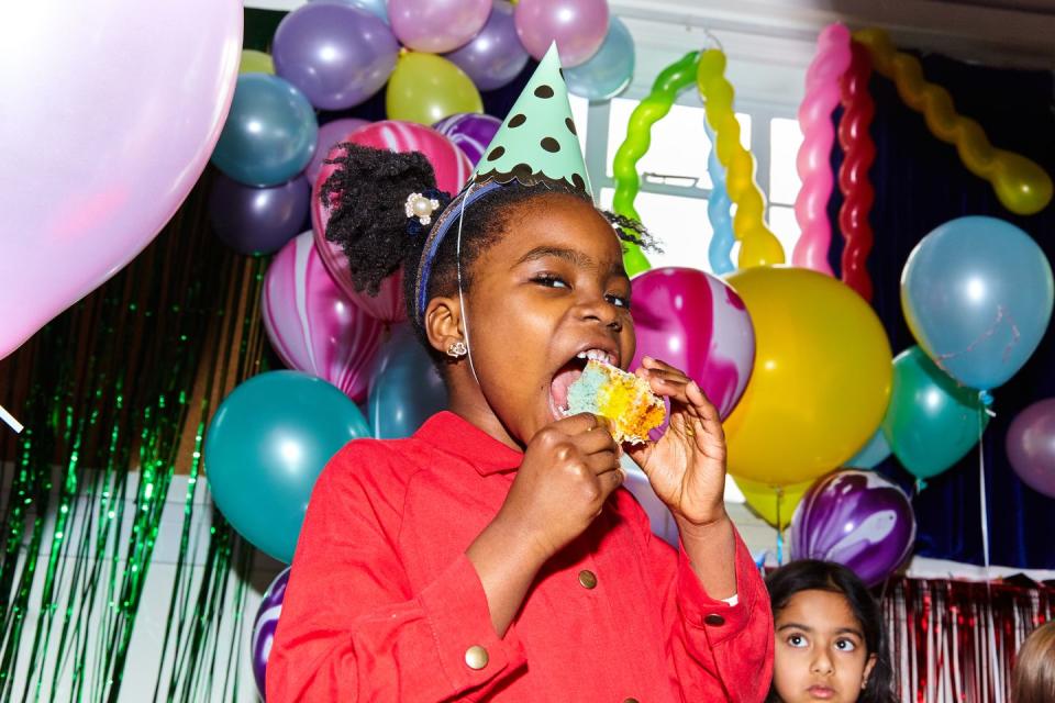 young girl having fun eating cake at a birthday celebration
