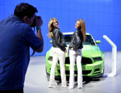 Models Lindsey Rae (L) and Lynsey Ramade pose with a Ford Mustang Boss 302 during the final press preview day for the North American International Auto Show in Detroit, Michigan, January 10, 2012. REUTERS/Mike Cassese