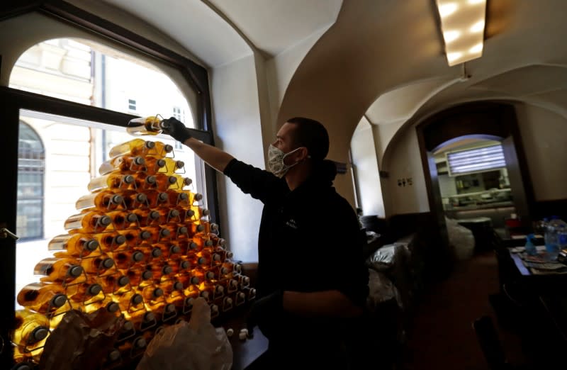 A bartender prepares plastic bottles inside of a closed pub in Prague