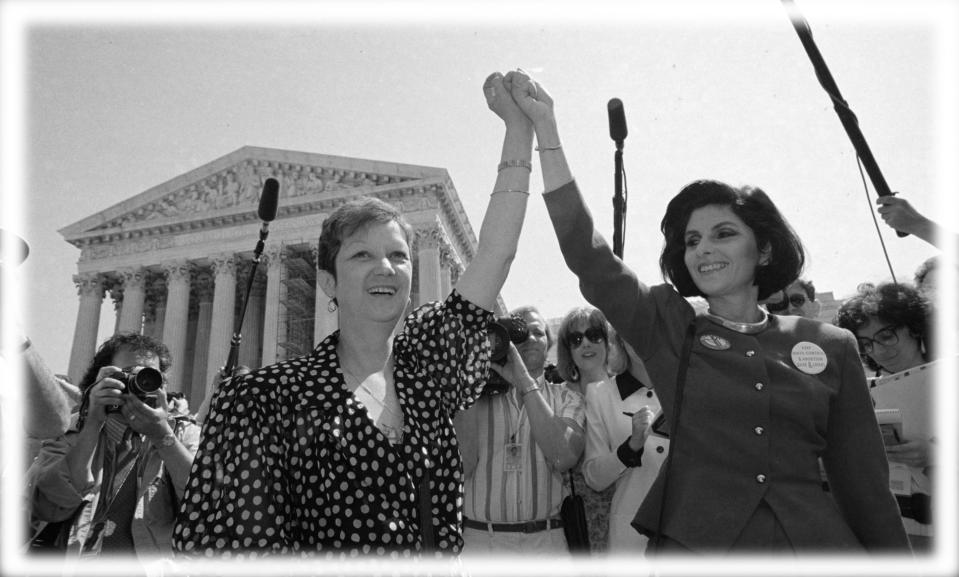 Norma McCorvey, Jane Roe in the 1973 court case, left, and her attorney Gloria Allred hold hands as they leave the Supreme Court building in Washington after sitting in while the court listened to arguments in a Missouri abortion case in April 1989. (Photo: J. Scott Applewhite/AP; digitally enhanced by Yahoo News)