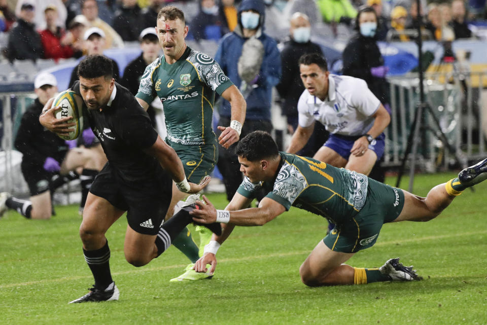 New Zealand's Richie Mo'unga, left, beats Australia's Noah Lolesio to score his during the Bledisloe rugby test between the All Blacks and the Wallabies at Stadium Australia, Sydney, Australia, Saturday, Oct. 31, 2020. (AP Photo/Rick Rycroft)