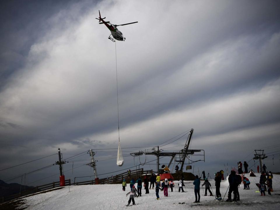 A helicopter brings snow to the lower slopes of Louchon-Superbagneres in the French Pyrenees: AFP via Getty Images