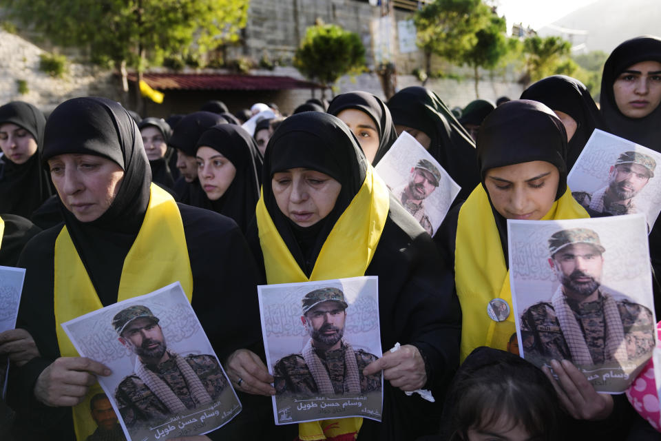 Mourners hold portraits of senior Hezbollah commander Wissam Tawil during his funeral procession in the village of Khirbet Selm, south Lebanon, Tuesday, Jan. 9, 2024. The elite Hezbollah commander who was killed in an Israeli airstrike Monday in southern Lebanon fought for the group for decades and took part in some of its biggest battles. (AP Photo/Hussein Malla)