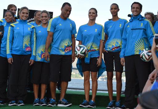 Los exjugadores brasileño Cafú (4º por la izquierda) y Juliano Belleti (D) posan junto a la actriz Fernanda Lima (3ª por la derecha) y la modelo Thais Ribeiro (2ª por la derecha) en la presentación de los uniformes oficiales que llevarán los voluntarios en el Mundial de Brasil, el 10 de abril de 2014, en Rio de Janeiro (AFP | VANDERLEI ALMEIDA)