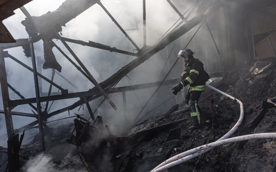 Firfighter in the remains of a factory which caught fire after Russian shelling