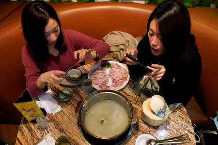 Customers take pictures of a durian hotpot at Coconut Chicken Hotpot Store in Shanghai, China November 14, 2018. REUTERS/Aly Song