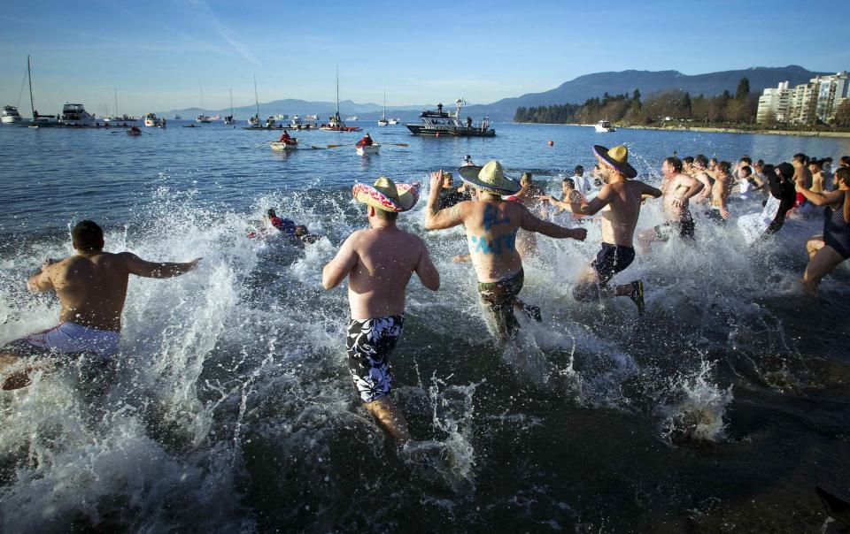 Participants run into English Bay during the 95th annual New Year's Day Polar Bear Swim in Vancouver, British Columbia January 1, 2015. REUTERS/Ben Nelms (CANADA - Tags: SOCIETY ENVIRONMENT ANNIVERSARY)