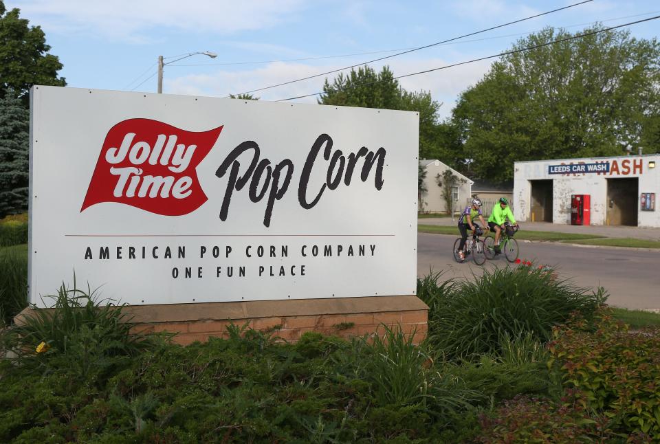RAGBRAI riders pass by the Jolly Time Popcorn plant in Sioux City.