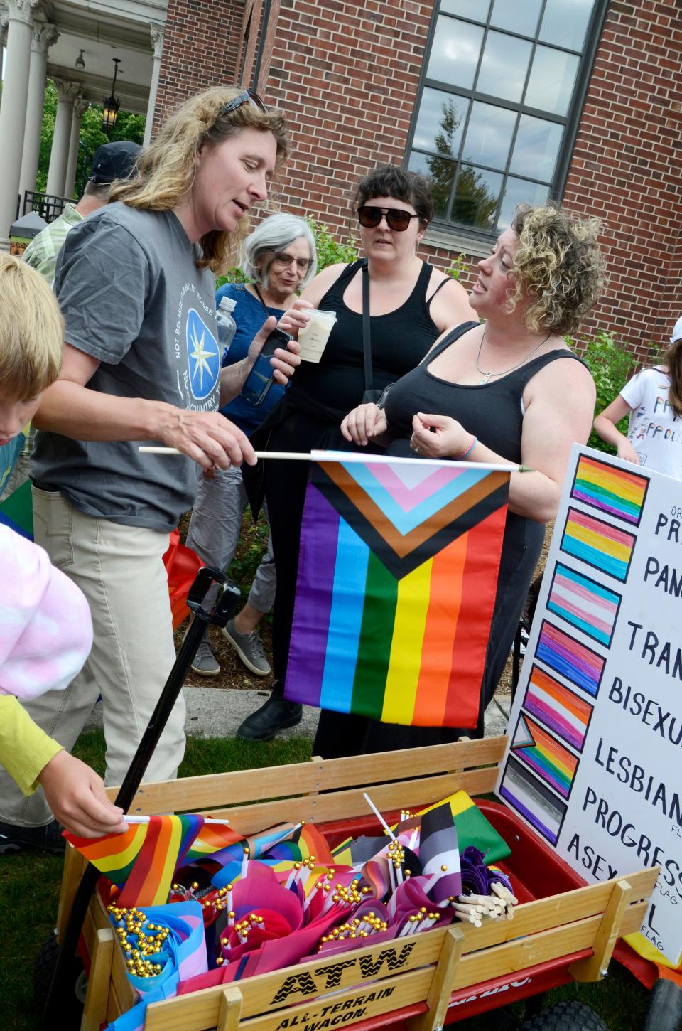 People pick out their free LGBTQ+ flags on June 28, 2022 prior to the annual Pride Month march, which started at the Petoskey District Library and continued to the green space in front of 200 E. Lake St. for a peaceful demonstration. The march coincided with the library’s kickoff event for its most recent Community Read series, which focused on Malinda Lo's "Last Night at the Telegraph Club.” Free copies of the book were available prior to the march.