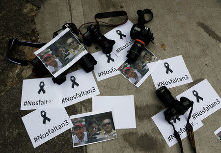 Colombian photographers leave the cameras on the floor in front of the Ecuadorean embassy to protest against the murder of journalist Javier Ortega, photographer Paul Rivas and their driver Efrain Segarra in Bogota, Colombia April 16, 2018. Picture taken April 16, 2018. REUTERS/Jaime Saldarriaga