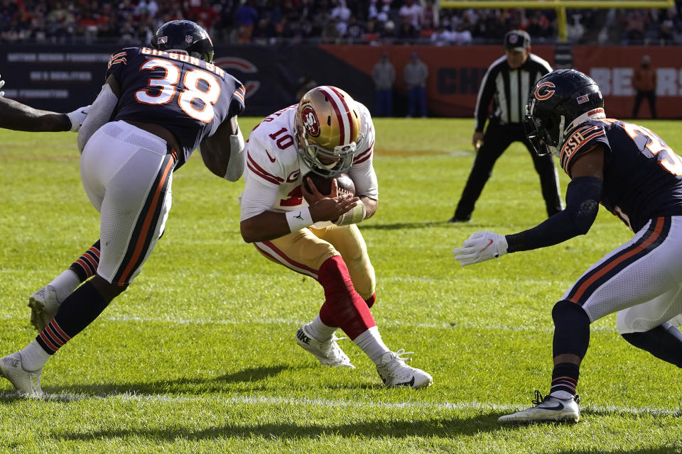 San Francisco 49ers quarterback Jimmy Garoppolo puts his head down and scores between Chicago Bears safety Tashaun Gipson (38) and DeAndre Houston-Carson during the second half of an NFL football game against the Chicago Bears Sunday, Oct. 31, 2021, in Chicago. (AP Photo/Nam Y. Huh)