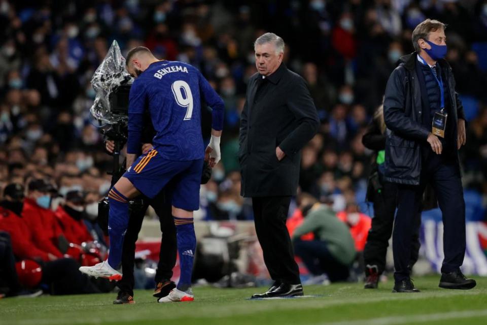 Karim Benzema shows Real Madrid coach Carlo Ancelotti where he has injured his knee.