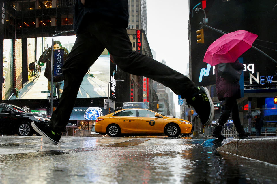 <p>A man jumps over a puddle in Times Square during a winter nor’easter in New York City, March 2, 2018. (Photo: Brendan McDermid/Reuters) </p>