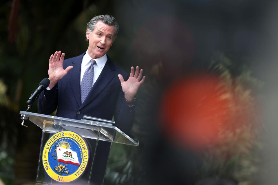 Gavin Newsom gestures with his palms up