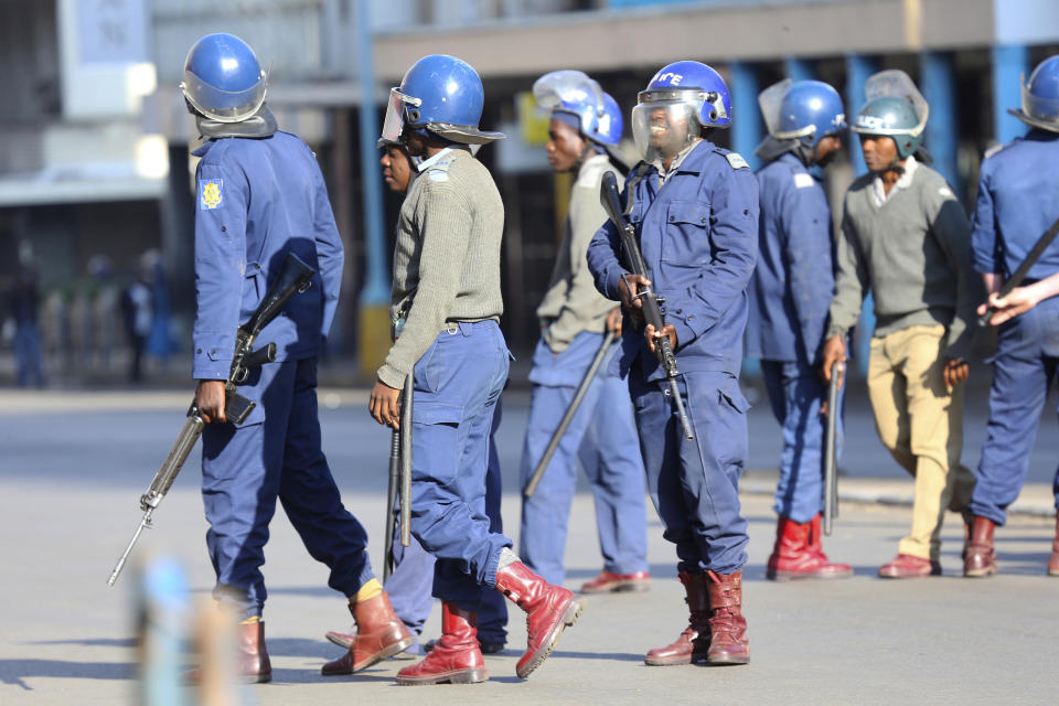 Armed riot police patrol the streets ahead of a planned protest in Harare, Friday, Aug. 16, 2019. Zimbabwe's police patrolled the streets of the capital Friday morning while many residents stayed home fearing violence from an anti-government demonstration planned by the opposition. (AP Photo/Tsvangirayi Mukwazhi)