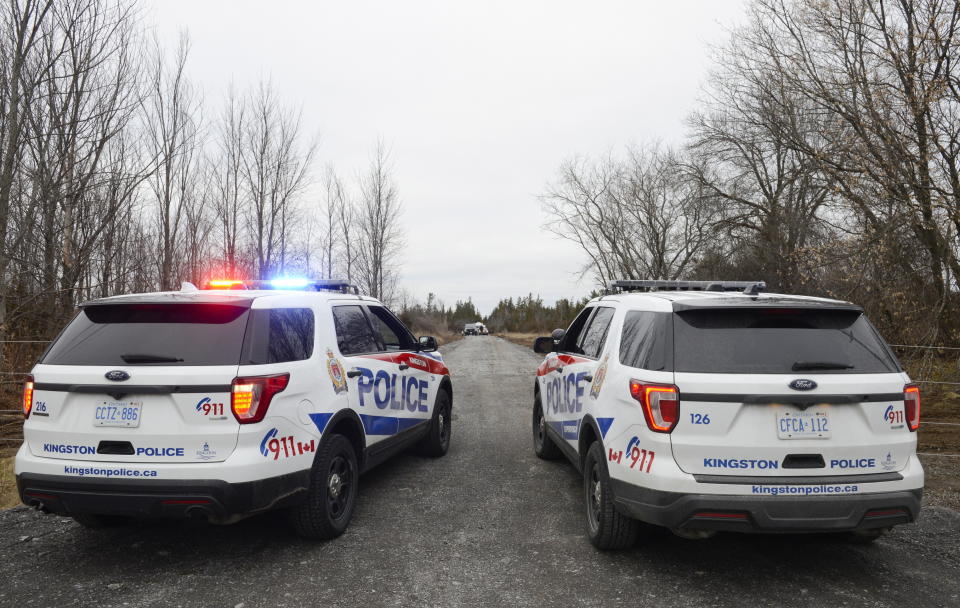 Two Kingston Police cars block a road leading to the site of a fatal plane crash in Kingston, Ontario, on Thursday, Nov. 28, 2019. (Sean Kilpatrick/The Canadian Press via AP)