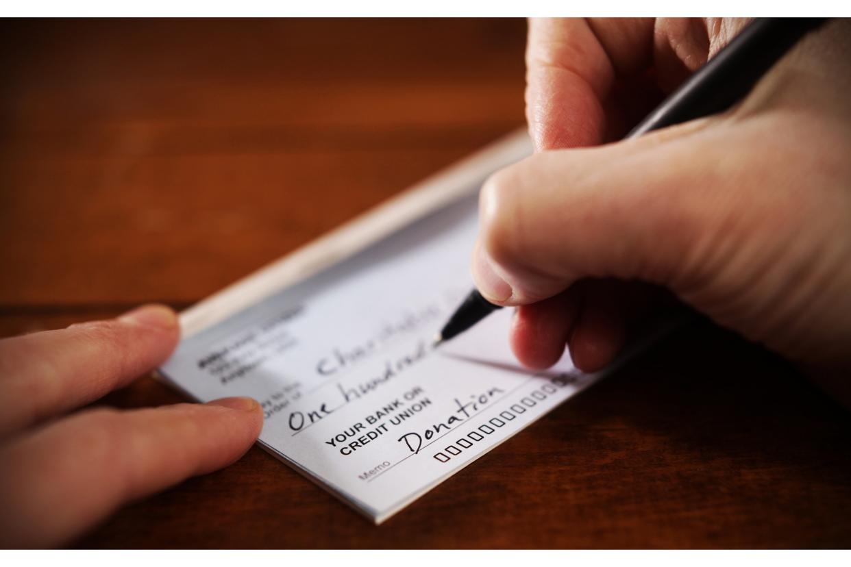 Closeup of person writing a donation check