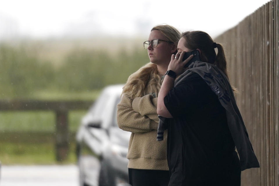 People pause after leaving a briefing for family members by Coast Guard and NTSB officials in Port Fouchon, La., Friday, April 16, 2021, after a lift boat capsized in the Gulf of Mexico during a storm on Tuesday. (AP Photo/Gerald Herbert)