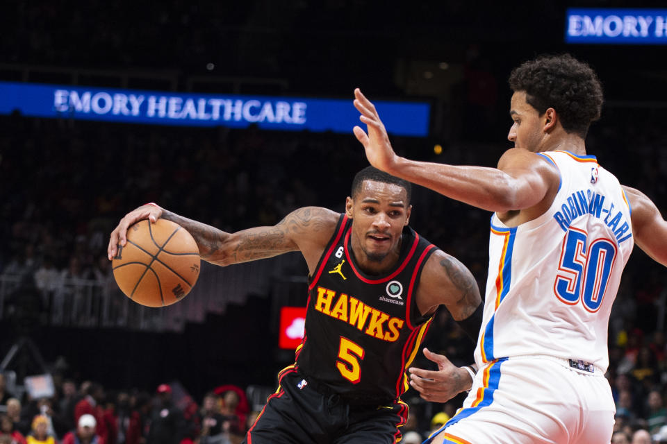 Atlanta Hawks guard Dejounte Murray drives to the basket against Oklahoma City Thunder forward Jeremiah Robinson-Earl during the second half of an NBA basketball game, Monday, Dec. 5, 2022, in Atlanta. (AP Photo/Hakim Wright Sr.)