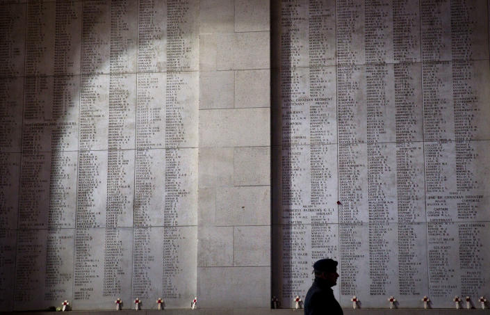 A soldier walks by wooden crosses and names of the missing during an Armistice ceremony at the Menin Gate in Ypres, Belgium, Sunday, Nov. 11, 2018. Sunday marks exactly 100 years since the end of the First World War. (AP Photo/Virginia Mayo)
