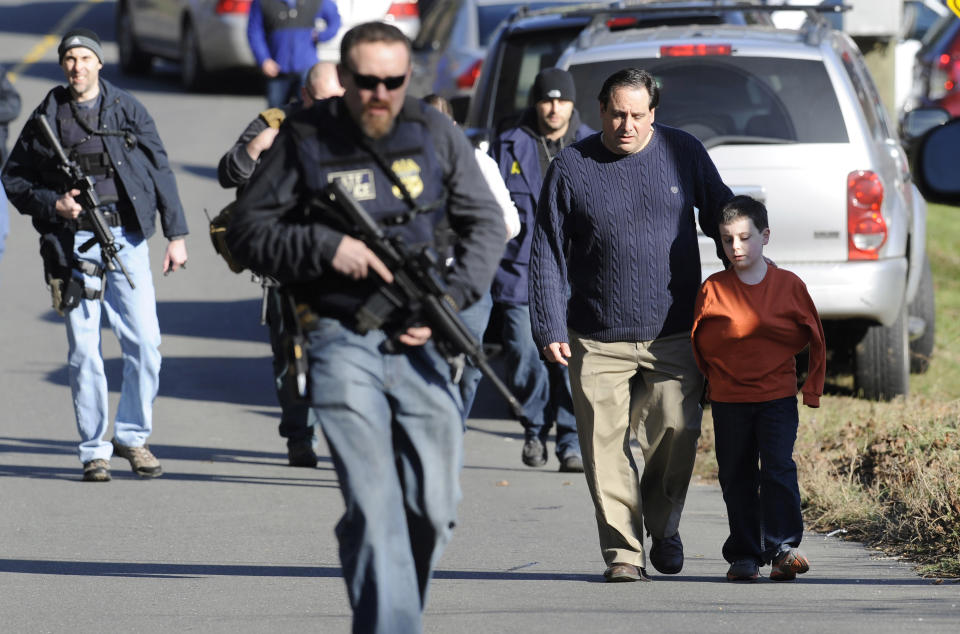 FILE - Parents leave a staging area after being reunited with their children following a shooting at the Sandy Hook Elementary School in Newtown, Conn., Dec. 14, 2012. A federal judge on Thursday, Aug. 3, 2023, rejected a request to temporarily block Connecticut's landmark 2013 gun control law, passed after the Sandy Hook Elementary School shooting, until a gun rights group's lawsuit against the statute has concluded. (AP Photo/Jessica Hill, File)