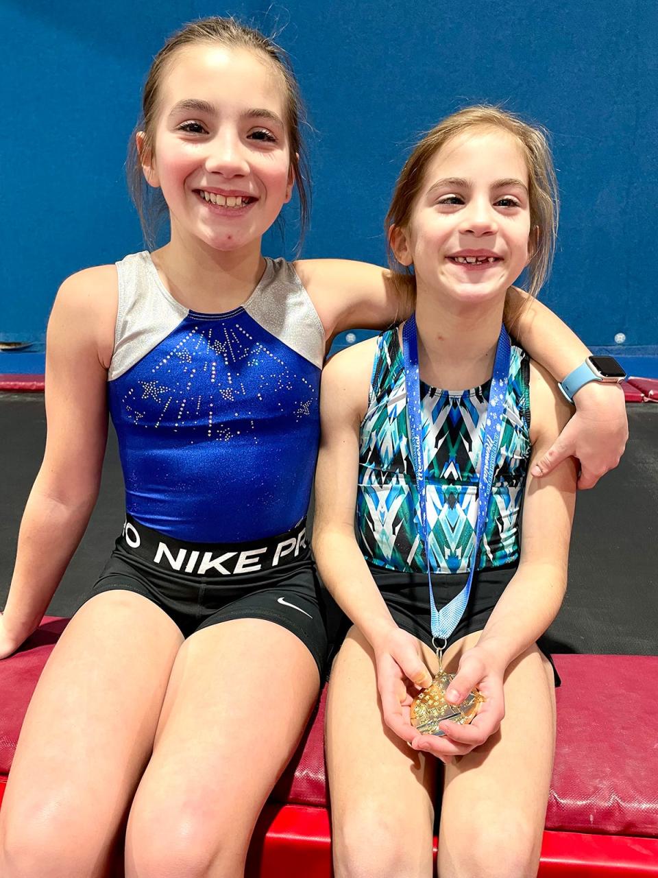 Iliana Grosso of Balance Gymnastics poses with her sister and teammate, Milla, during a break in practice this week.