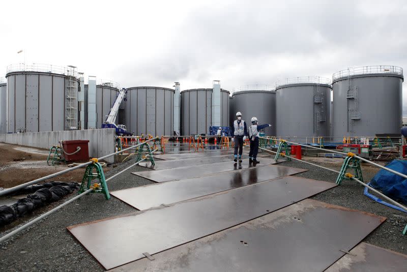 Workers are seen near storage tanks for radioactive water at tsunami-crippled Fukushima Daiichi nuclear power plant in Okuma town, Fukushima prefecture, Japan