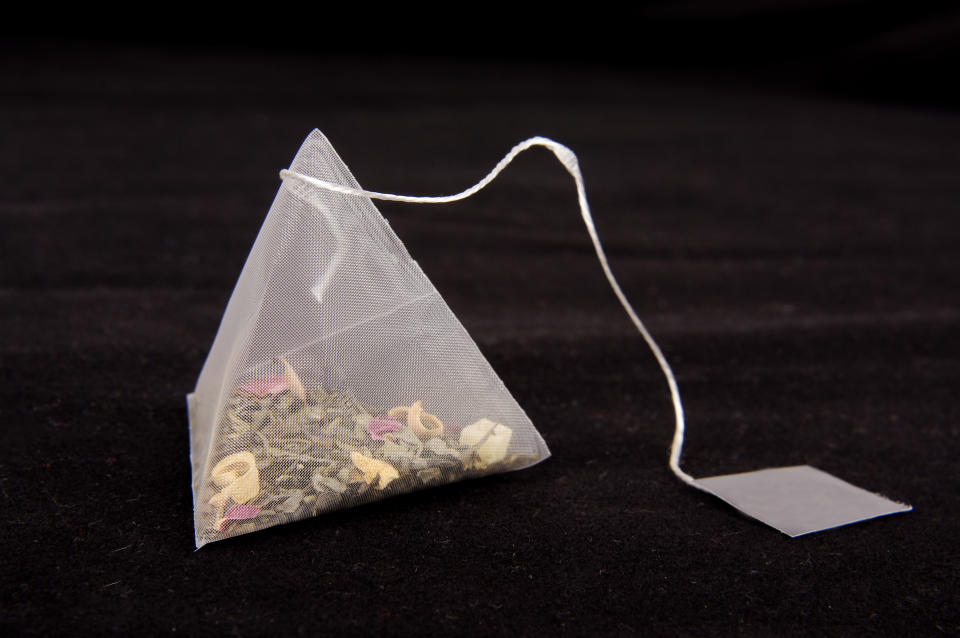 Teabag in the pyramid shape on the dark background