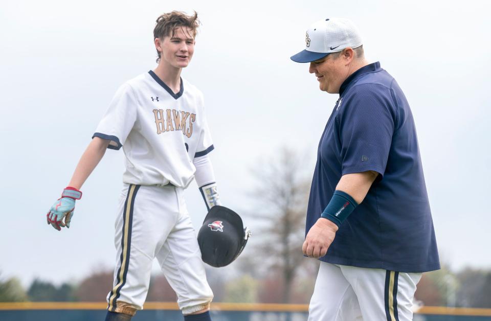 Council Rock South's Jake Andrews (9), left, jokes with JV baseball coach TJ Farrell in a game against Council Rock North.