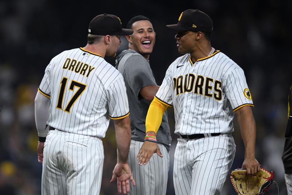 Brandon Drury, Manny Machado and Juan Soto ceelbrate the Padres' win on Wednesday.