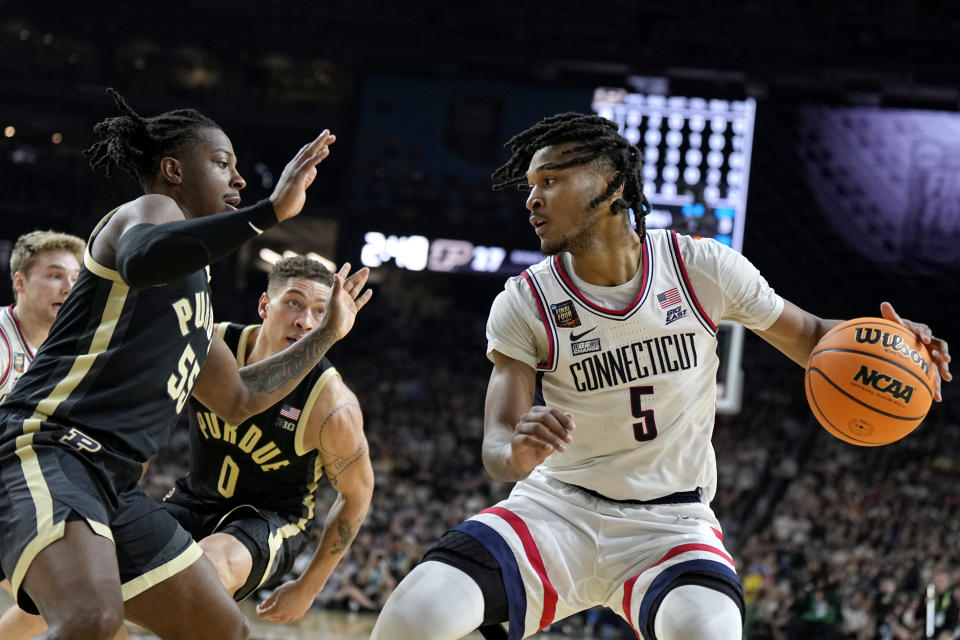 FILE - UConn guard Stephon Castle (5) drives as Purdue guard Lance Jones defends during the first half of the NCAA college Final Four championship basketball game, Monday, April 8, 2024, in Glendale, Ariz. Castle is considered to be among the top prospects in this month’s NBA draft. (AP Photo/Brynn Anderson, File)