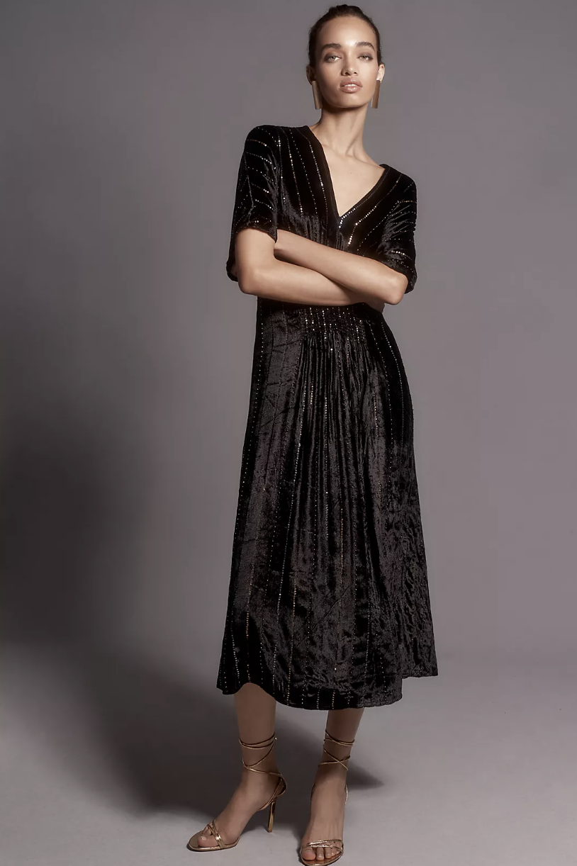 model standing in black velvet dress with sleeves, Bl-nk The Tatiana Kaftan: Velvet Edition (photo via Anthropologie)