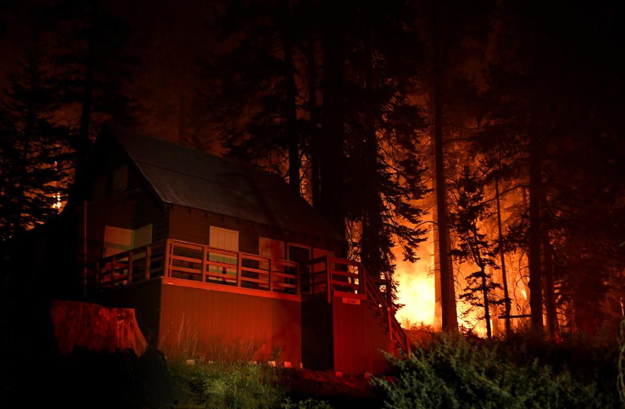 <span class="caption">A cabin is illuminated by firetruck lights as the Caldor Fire burns near Lake Tahoe in California on Aug. 31, 2021.</span> <span class="attribution"><a class="link " href="https://www.gettyimages.com/detail/news-photo/lake-tahoe-ca-august-31-2021-a-cabin-is-illuminated-by-fire-news-photo/1234991812" rel="nofollow noopener" target="_blank" data-ylk="slk:Wally Skalij/Los Angeles Times via Getty Images;elm:context_link;itc:0;sec:content-canvas">Wally Skalij/Los Angeles Times via Getty Images</a></span>