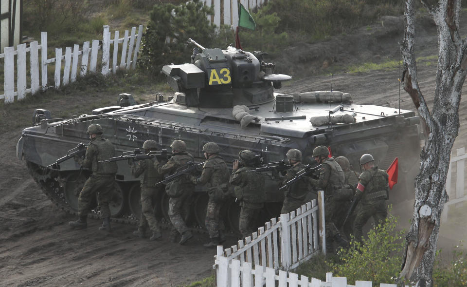 FILE - Soldiers follow a Marder infantry fighting vehicle during a demonstration event held for the media by the German Bundeswehr in Bergen near Hannover, Germany, on Sept. 28, 2011. Defense officials said Monday Dec. 19, 2022 that Germany is readying decades-old armored personnel carriers for a key NATO unit after the modern vehicles that should have been deployed suffered a mass breakdown. (AP Photo/Michael Sohn, File)