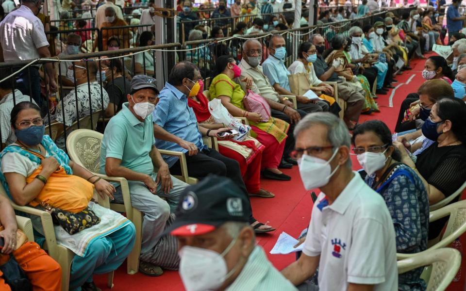 People queue up to receive a dose of a Covid-19 coronavirus vaccine at a vaccination centre in Mumbai on April 27, 2021.  - PUNIT PARANJPE /AFP