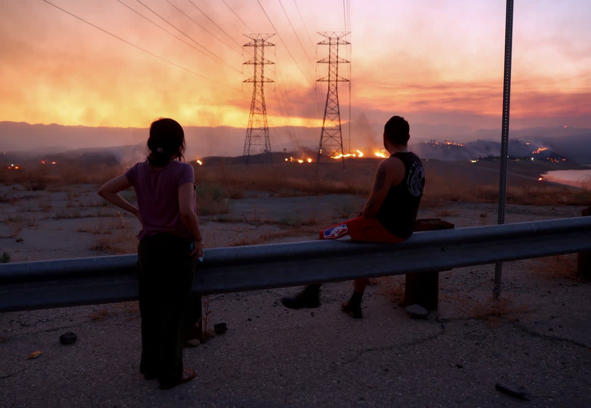 People evacuated from the Route Fire in Los Angeles County in 2023 watch the blaze burn. A massive heatwave in California this week raises concerns of more fires  (Getty Images)