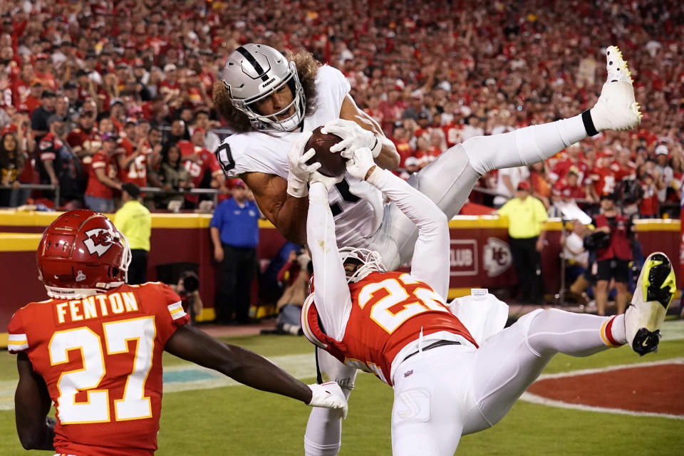 Las Vegas Raiders wide receiver Mack Hollins (10) is unable to catch a pass in the end zone as Kansas City Chiefs safety Juan Thornhill (22) and cornerback Rashad Fenton (27) defend during the second half of an NFL football game Monday, Oct. 10, 2022, in Kansas City, Mo. (AP Photo/Charlie Riedel)