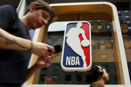 The NBA logo is displayed as people pass by the NBA Store in New York