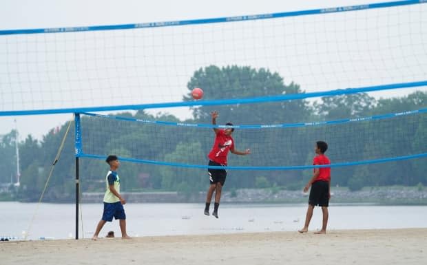 A trio of volleyball players play at Britannia Beach in Ottawa on Tuesday, July 20, 2021.  (Sean Kilpatrick/The Canadian Press - image credit)